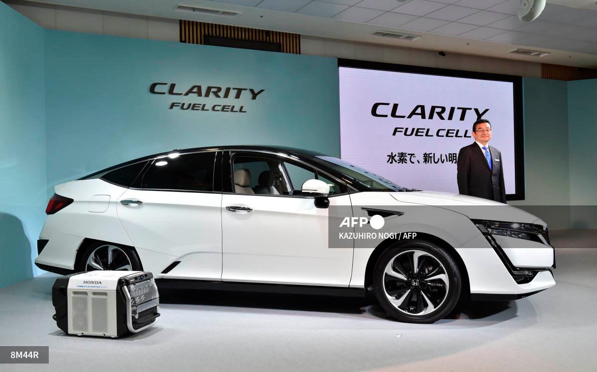 Honda Motors President Takahiro Hachigo poses with its new fuel cell vehicle (FCV), the Clarity Fuel Cell during a press preview at the company’s headquarters in Tokyo on March 10, 2016. (Photo by KAZUHIRO NOGI / AFP)