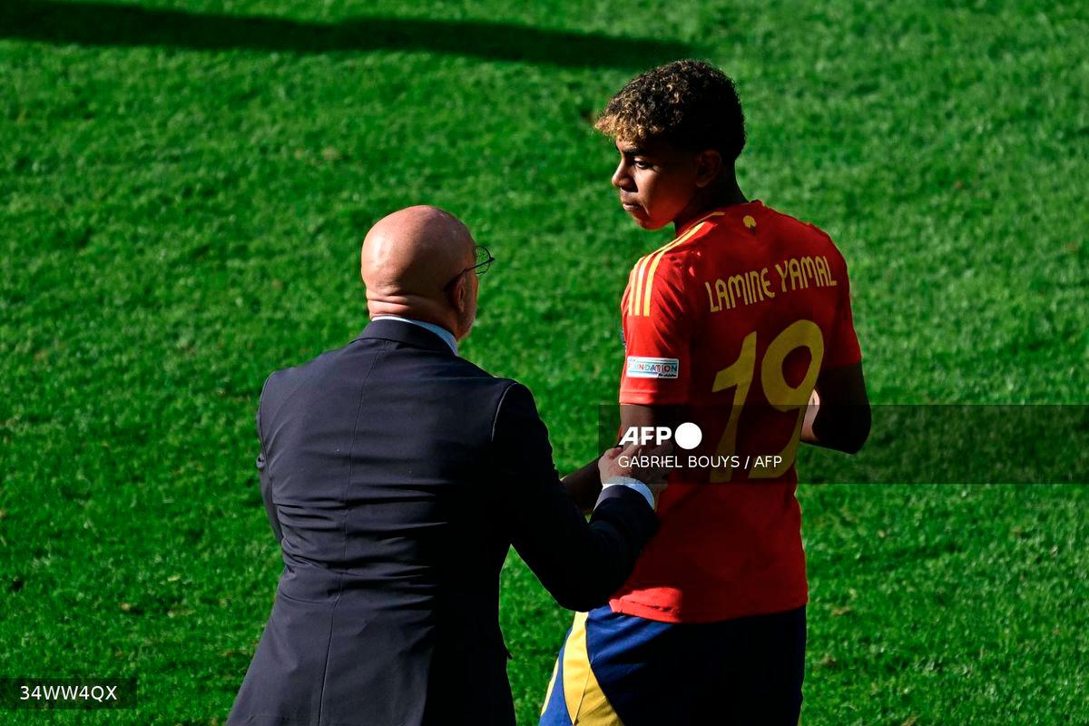 Spain's head coach Luis de la Fuente speaks with Spain's forward #19 Lamine Yamal during the UEFA Euro 2024 Group B football match between Spain and Croatia at the Olympiastadion in Berlin on June 15, 2024. - AFP