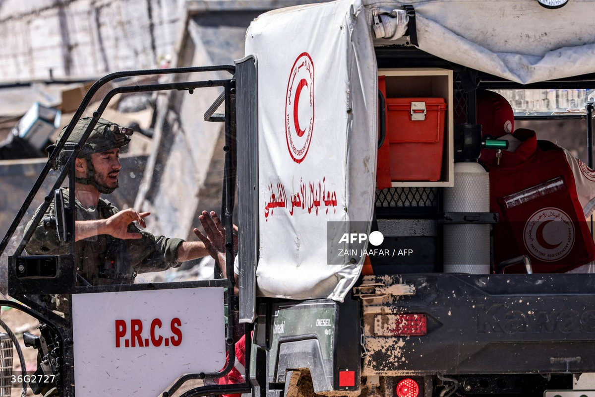 Israeli army soldiers positioned at the entrance of the Tulkarm camp for Palestinian refugees inspect a vehicle used by the Palestinian Red Crescent Society arriving at the scene, during an ongoing raid on the camp in the north of the occupied West Bank on September 12, 2024. - AFP