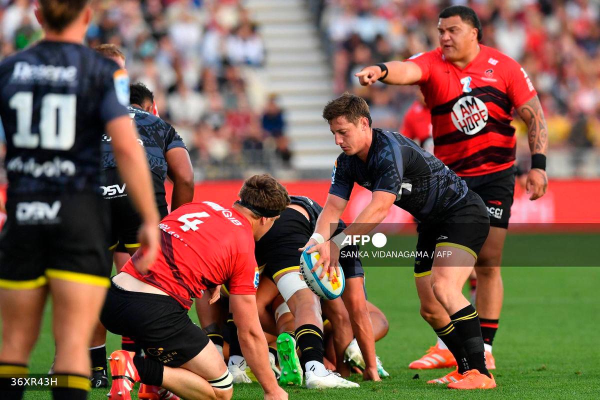 Hurricanes’ Cameron Roigard (2nd R) passes the ball during round one of the Super Rugby Pacific match between the Crusaders and Hurricanes at Apollo Projects Stadium in Christchurch on February 14, 2025. (Photo by Sanka Vidanagama / AFP)