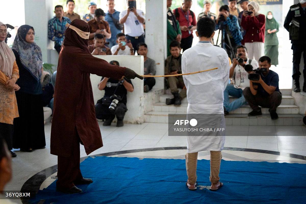 A man, found guilty of sexual relations with another man under the strict Islamic sharia law, is publicly flogged in Banda Aceh on February 27, 2025. (Photo by YASUYOSHI CHIBA / AFP)