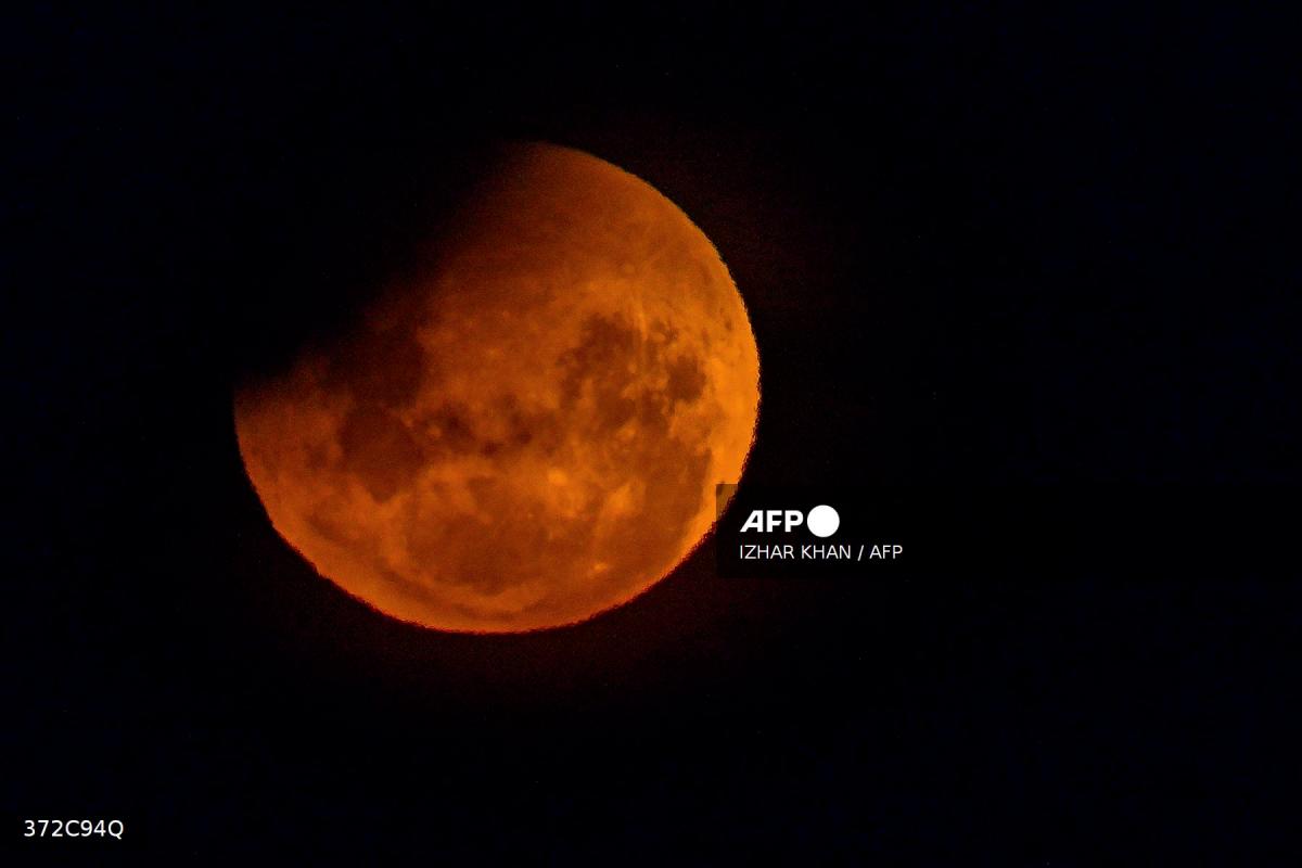 A full moon, also known as the Blood Moon, is seen during a partial eclipse in the sky over Lake George near the Australian capital city of Canberra on March 14, 2025. Stargazers across a swathe of the world marvelled at a dramatic red Blood Moon during a rare total lunar eclipse in the early hours of March 14. - AFPPIX