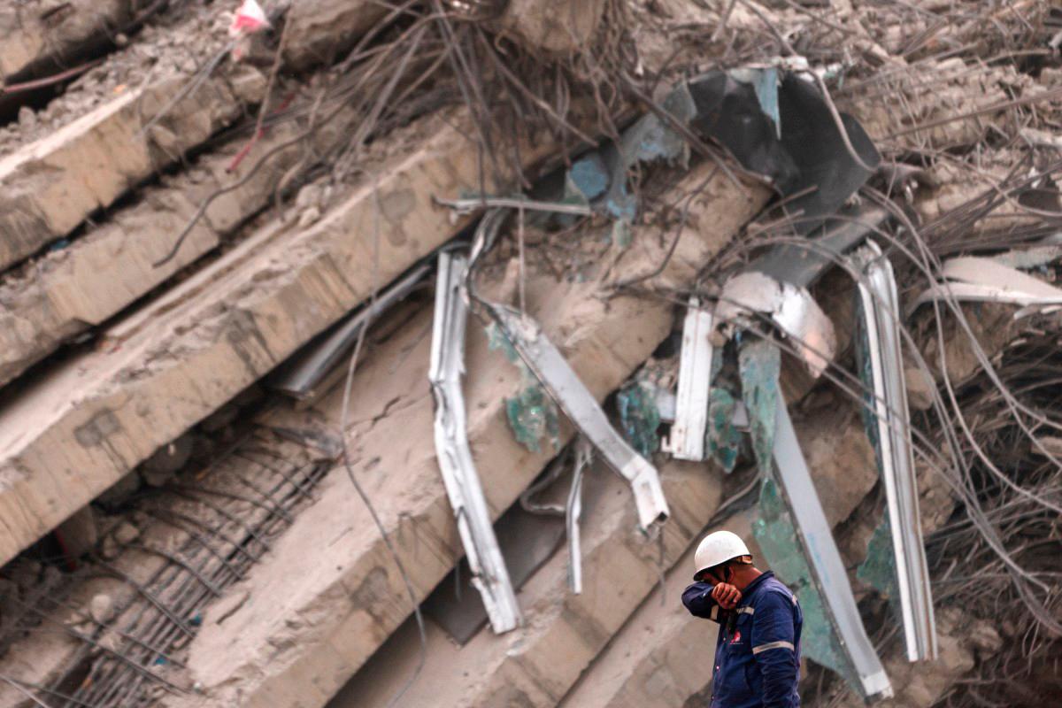 A rescue worker wipes his face with his elbow at the site of an under-construction building collapse in Bangkok on April 2, 2025, five days after an earthquake struck central Myanmar and Thailand. (Photo by Chanakarn Laosarakham / AFP)