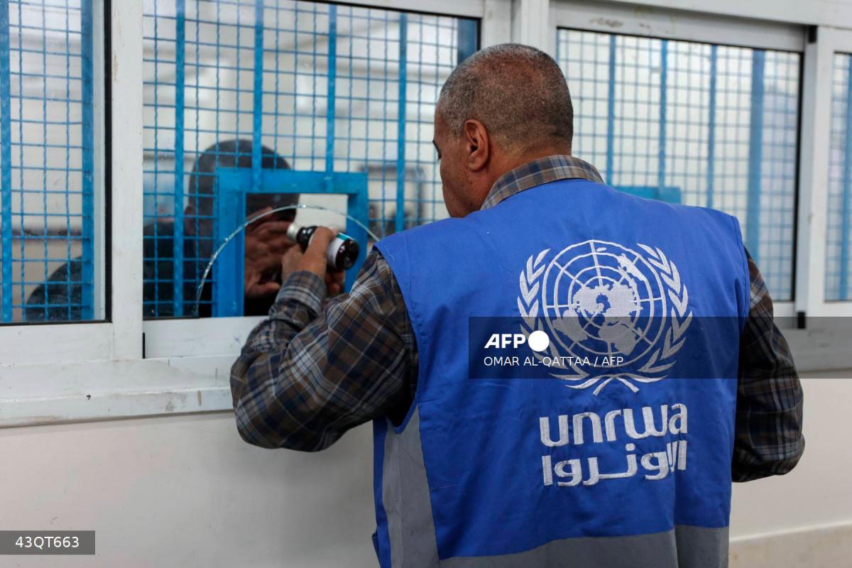 A member of staff dispenses a dose of medication to Palestinians at the UNRWA-run clinic at al-Shati refugee camp west of Gaza City on April 28, 2025. - AFPPIX