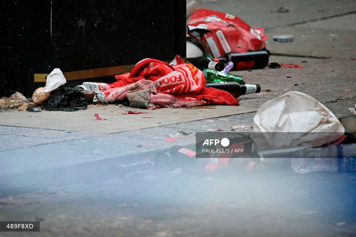 Discarded Liverpool scarves and flags lay in the road behind a police cordon on Water Street in Liverpool, north-west England on May 27, 2025, after a car ploughed in to crowds gathered to watch an open-top bus victory parade for Liverpool's Premier League trophy parade on May 26. - AFP