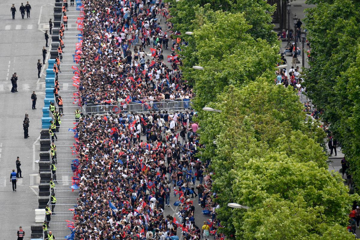 Paris Saint-Germain’s supporters gather as they wait for the team bus to parade on the Champs-Elysees avenue in Paris on June 1, 2025, a day after PSG won the 2025 UEFA Champions League final football match against Inter Milan in Munich. (Photo by Guillaume SOUVANT / AFP)