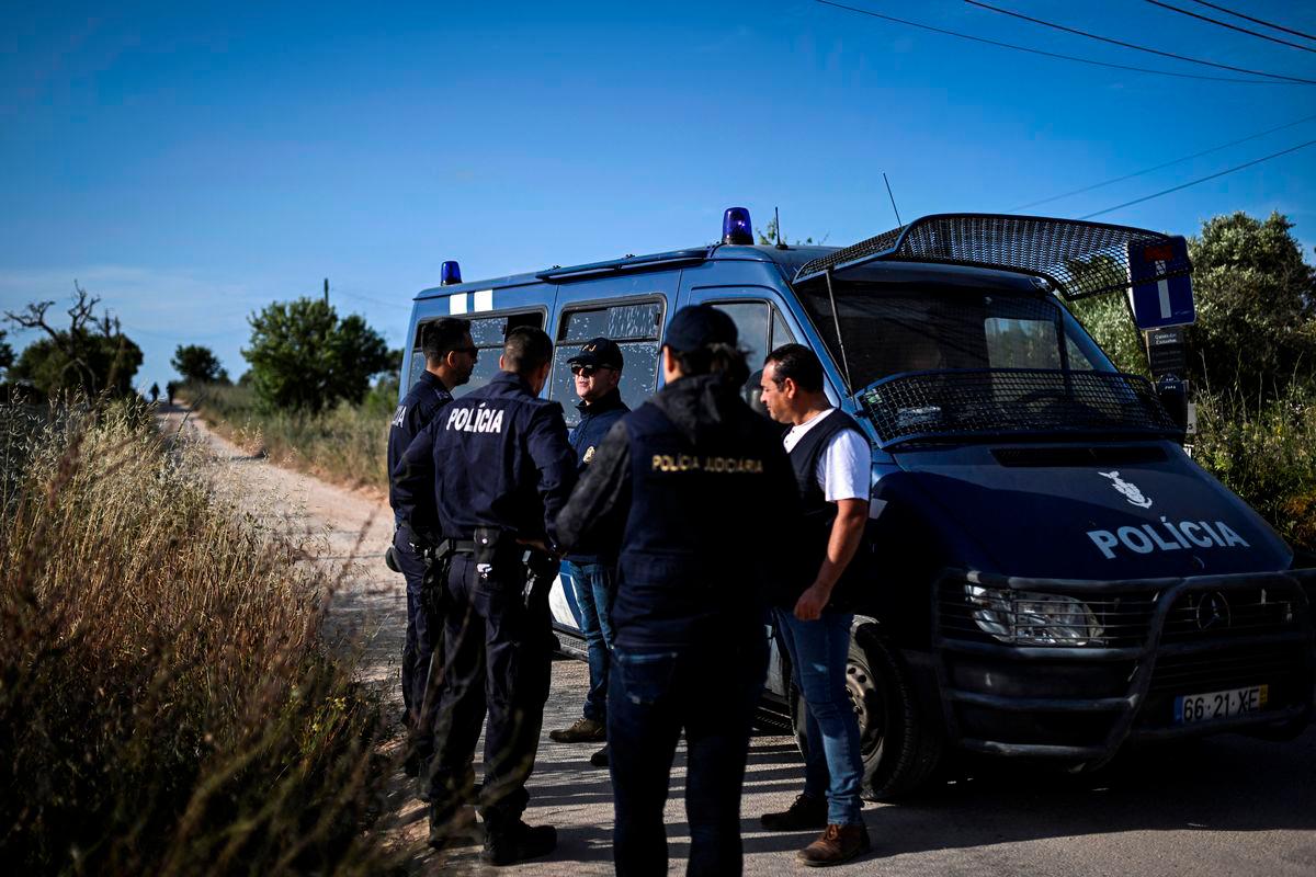 Portuguese Criminal Investigation Police (PJ) investigators stand in a road for a new search operations amid the investigation into the disappearance of Madeleine (or Maddie) McCann in Lagos, in the Algarve region, on June 3, 2025. (Photo by Patricia DE MELO MOREIRA / AFP)