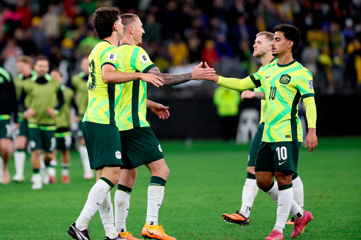 Australia’s Daniel Arzani (R) celebrates victory with teammates after the 2026 FIFA World Cup Asian Qualifier football match between Australia and Japan at Optus Stadium in Perth on June 5, 2025. (Photo by COLIN MURTY / AFP)