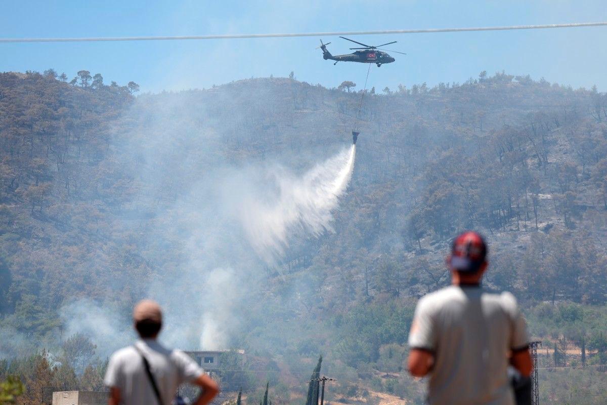 A Turkish helicopter helps battle a forest fires in the coastal Syrian province of Latakia on July 5, 2025. (Photo by OMAR HAJ KADOUR / AFP)