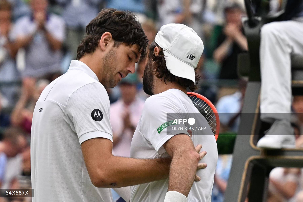Australia’s Jordan Thompson (R) greets US player Taylor Fritz after withdrawing from their men’s singles fourth round tennis match on the seventh day of the 2025 Wimbledon Championships at The All England Lawn Tennis and Croquet Club in Wimbledon, southwest London, on July 6, 2025. - AFP