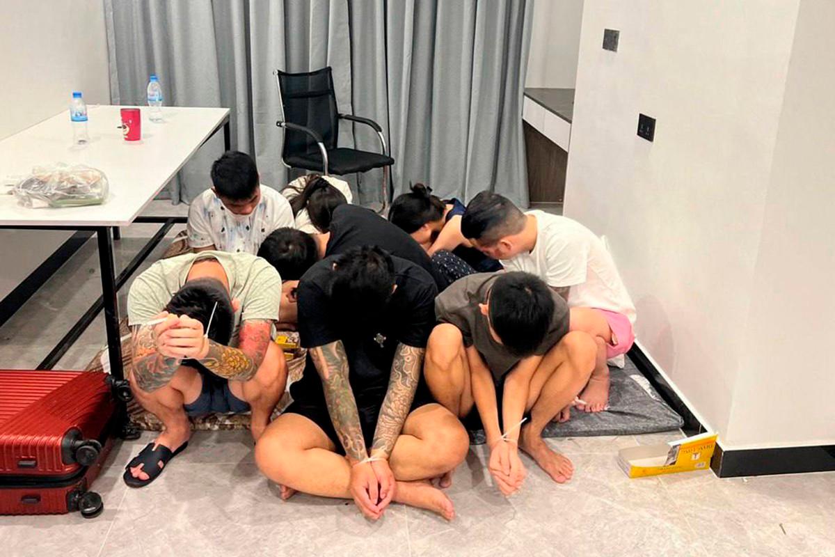 This pool photo taken on July 14, 2025 and released on July 16 by Agence Kampuchea Presse (AKP) shows suspects with their hands ziptied after being detained during a raid on a scam centre in Phnom Penh. (Photo by POOL / AFP)