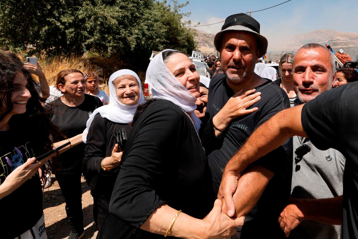Shadi Abu Zaid (C), a Syrian Druze man, is received by members of the Druze community as he arrives in the Druze village of Majdal Shams in the Israeli-annexed Golan Heights on July 16, 2025. (Photo by Jalaa MAREY / AFP)