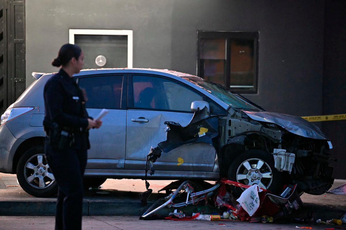 Officers stand at the scene of a crashed vehicle which drove into a crowd in Hollywood in the early hours of July 19, 2025, injuring 28 people, according to the Los Angeles Fire Department. - AFP