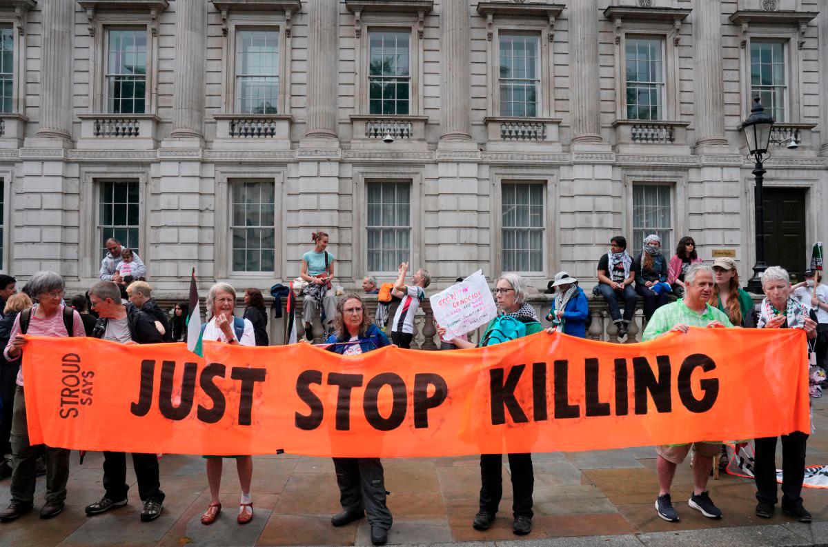 Pro-Palestinian supporter hold a banner that reads ‘Just stop killing’ on Downing Street in central London, on July 19, 2025, as they take part in a ‘National March for Palestine’ organised by the Palestine Solidarity Campaign. - AFP