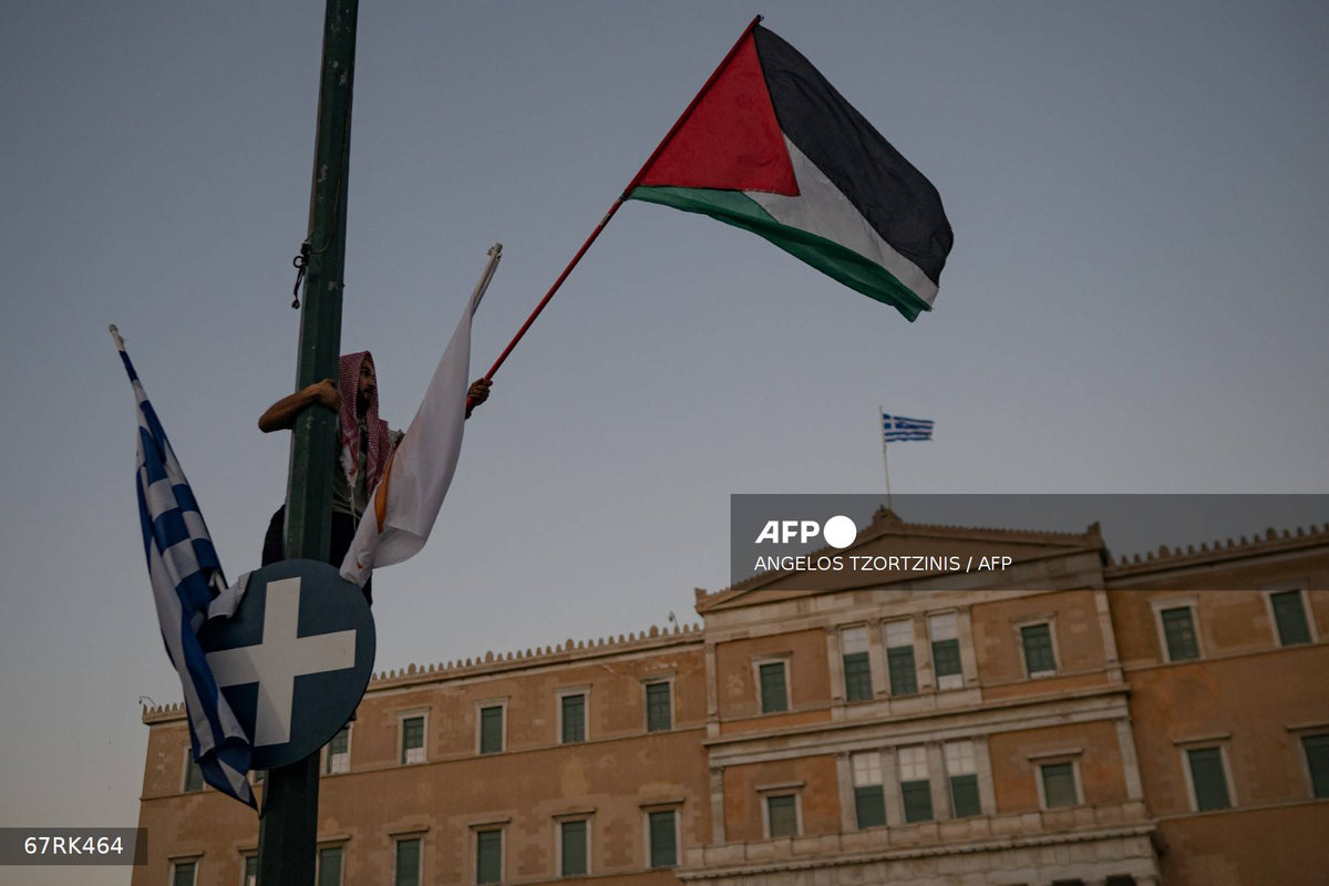 A demonstrator waves a palestinian flag during a protest in support of Palestinians and calling against the ongoing food shortages in the Gaza Strip, in Athens on July 24, 2025. - AFP