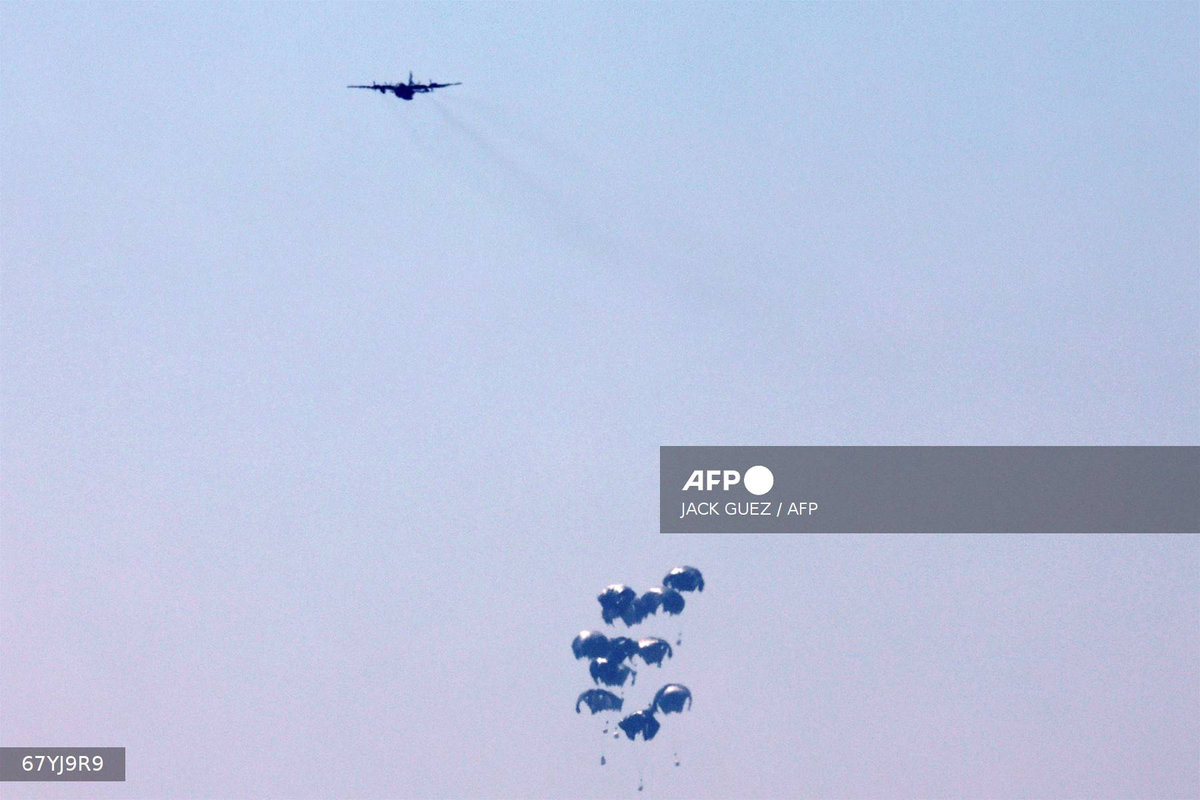 Humanitarian aid is dropped on the Gaza Strip as pictured from a position along the border in southern Israel on July 27, 2025. - AFP