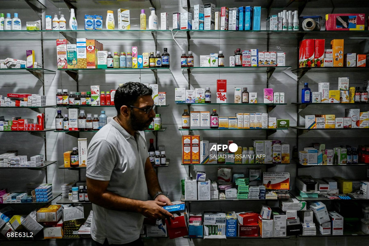 A pharmacist works at his shop in New Delhi on July 31, 2025. - AFP