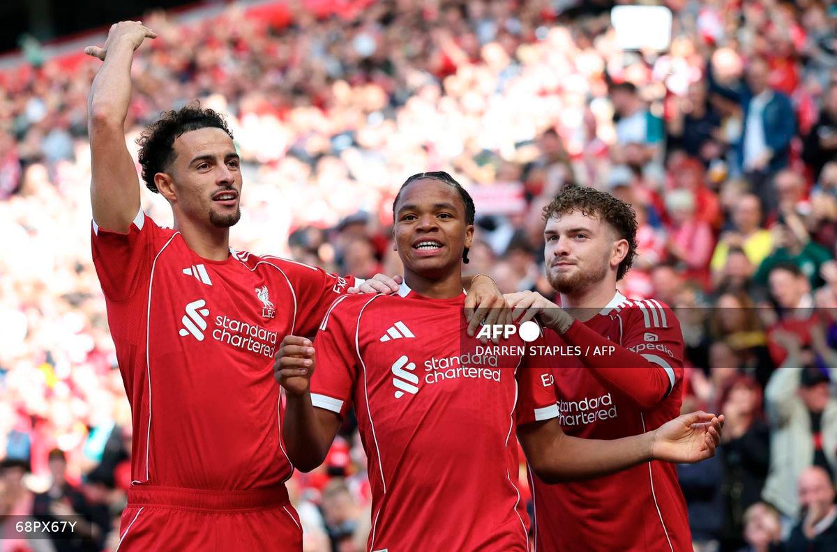 Liverpool's English striker #73 Rio Ngumoha (C) celebrates scoring the opening goal with Liverpool's English midfielder #17 Curtis Jones (L) and Liverpool's English midfielder #19 Harvey Elliott during the first of two pre season friendly football matches between Liverpool and Athletic Bilbao at Anfield in Liverpool, north west England on August 4, 2025. - AFP