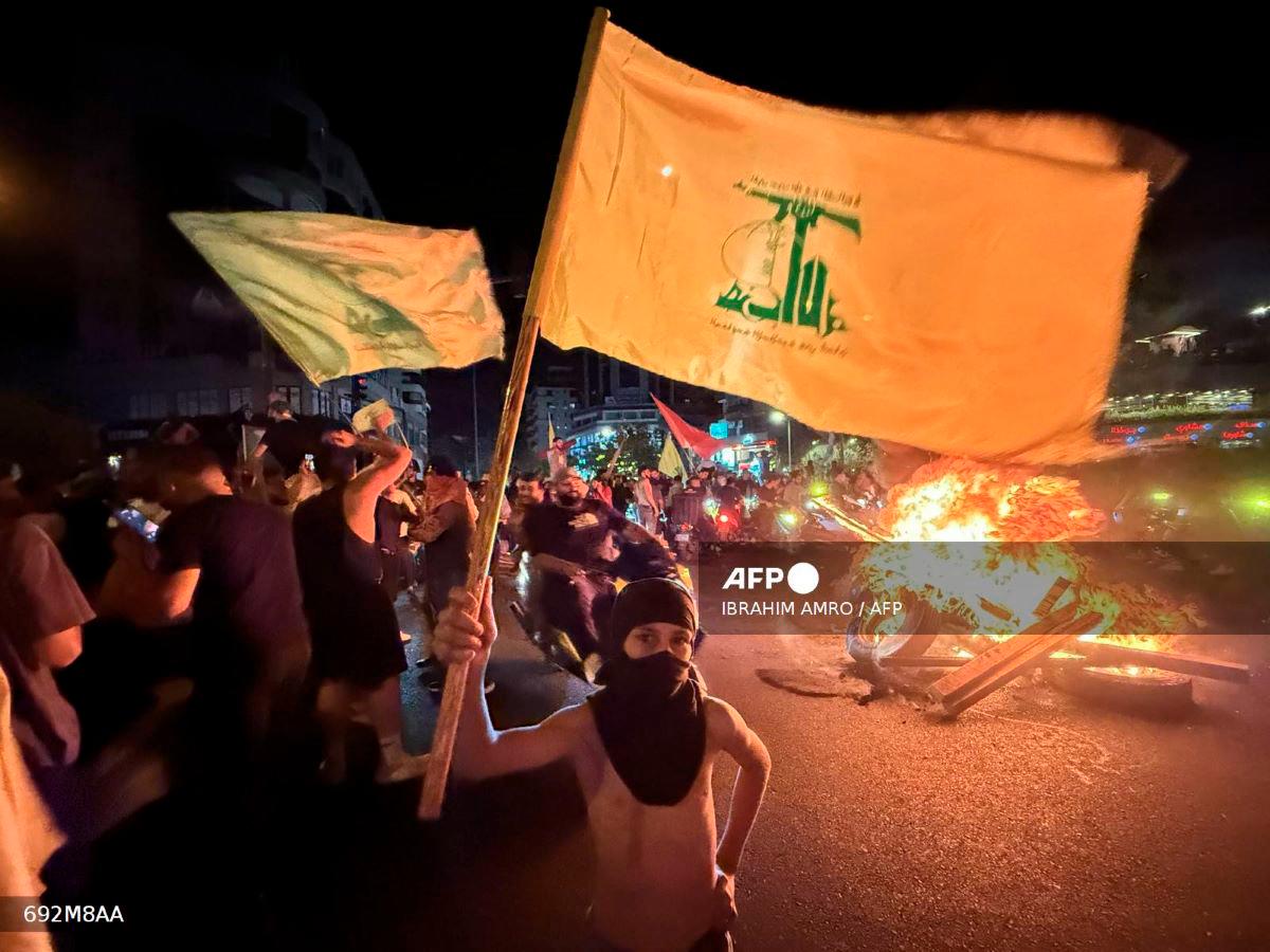 Supporters of Lebanon’s Hezbollah militant group block the streets with burning tires as they rally in cars and motorbikes to protest the government’s endorsement of a plan to disarm it, in Beirut’s southern suburbs early on August 8, 2025. - AFP