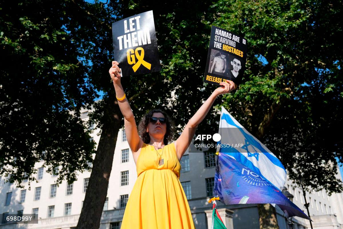 A person holds placards during a ‘National march for the Hostages’ organised by Stop the Hate UK, in central London on August 10, 2025. (Photo by CARLOS JASSO / AFP)