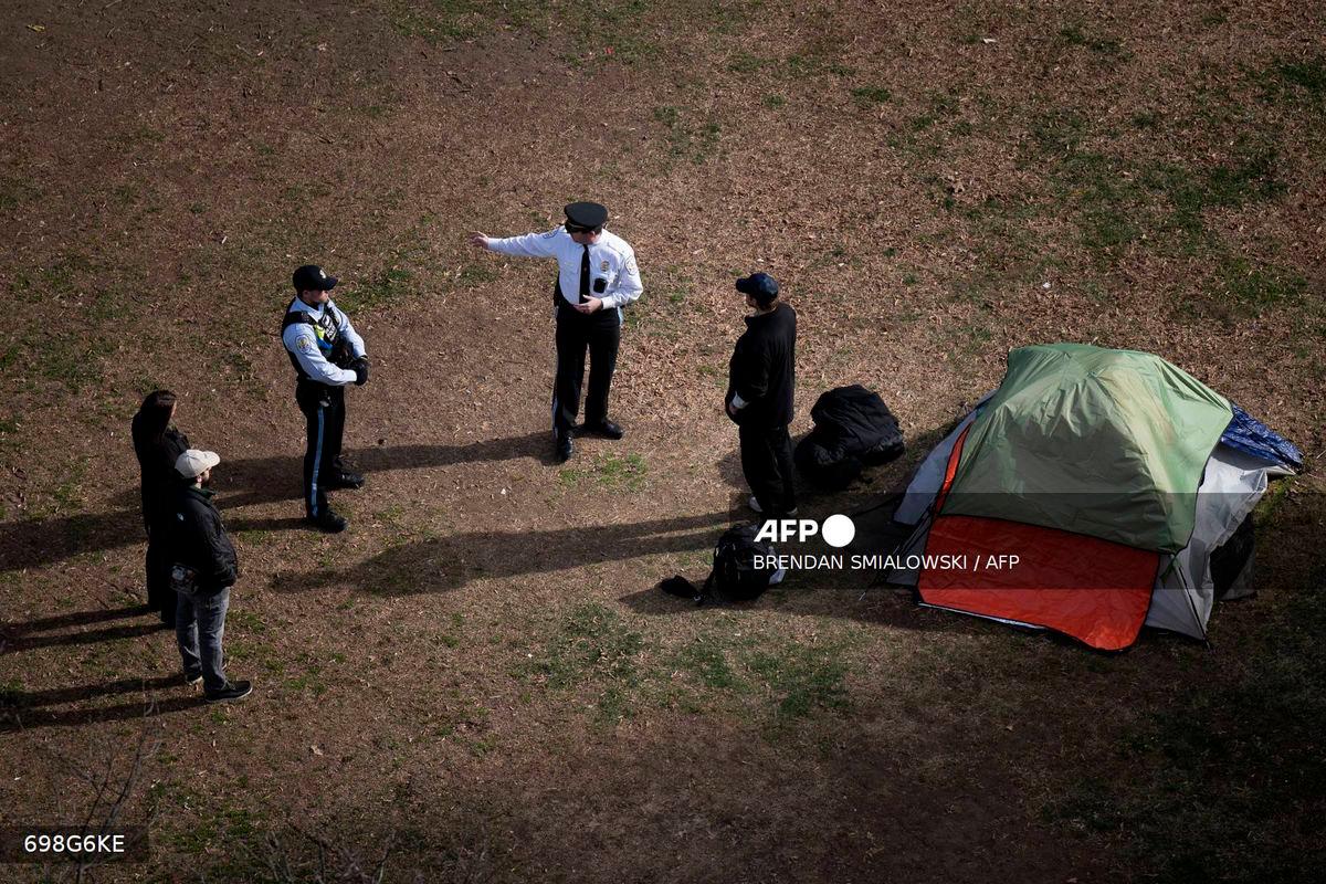 Park Police talk to a man who refused to leave after members of the US National Park Service cleared a homeless encampment from McPherson Square, two blocks from the White House in Washington, DC, on February 15, 2023. (Photo by Brendan Smialowski / AFP)