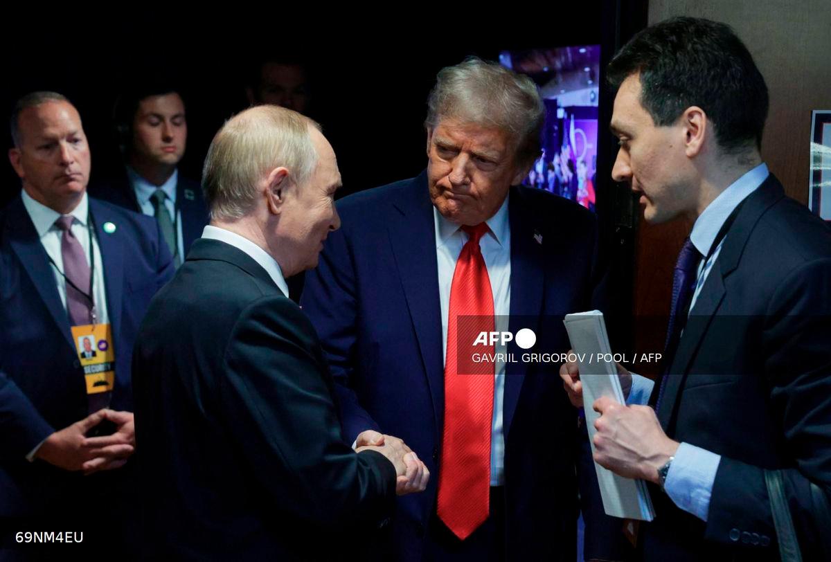 In this pool photograph distributed by the Russian state agency Sputnik, US President Donald Trump (C) and Russian President Vladimir Putin (L) shake hands after delivering a joint press conference following a US-Russia summit on Ukraine at Joint Base Elmendorf-Richardson in Anchorage, Alaska, on August 15, 2025. - POOL via AFP