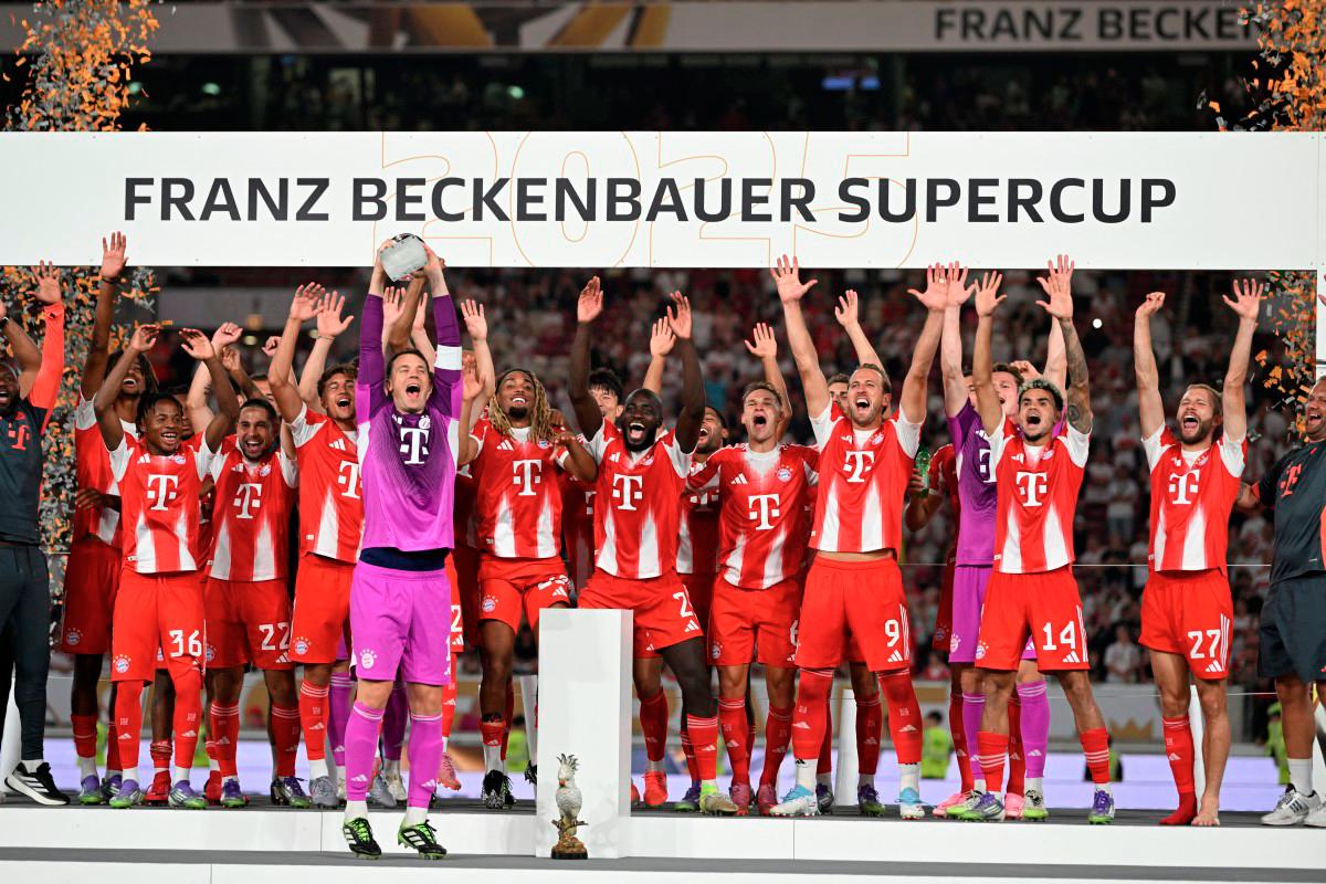 Munich’s team celebrates on the podium with the trophy after the Franz-Beckenbauer Supercup football match between VfB Stuttgart and FC Bayern Munich in Stuttgart, southern Germany. - AFP