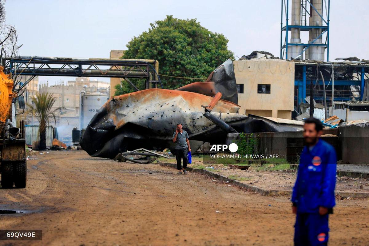 A man walks as another looks on at the site of an Israeli airstrike that targeted the Haziz power station south of the Huthi-run Yemeni capital Sanaa on August 17, 2025. (Photo by Mohammed HUWAIS / AFP)