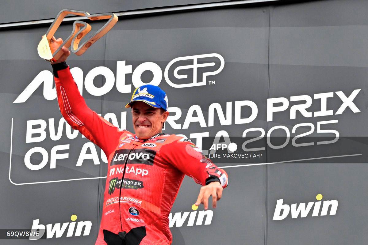 Winner Ducati Lenovo team's Spanish rider Marc Marquez jumps on the podium as he celebrates after the Austrian MotoGP Grand Prix at the Red Bull Ring race track in Spielberg, Austria, on August 17, 2025. - AFP