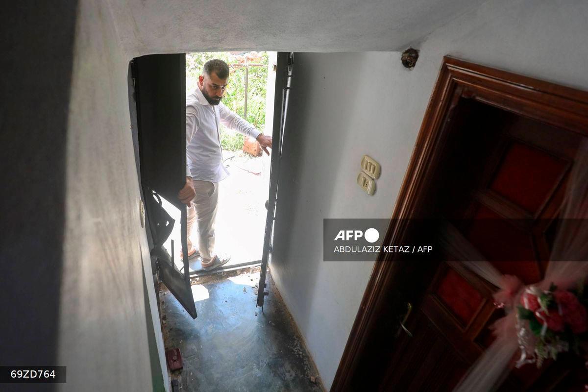 A man opens the door to a house, the site of a reported operation by the US-led coalition, in the town of Atme in northwestern Syria on August 20, 2025. (Photo by Abdulaziz KETAZ / AFP)