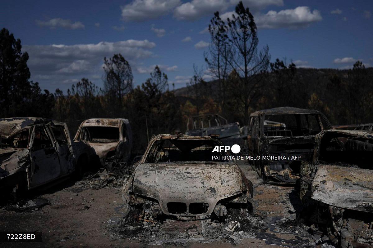 Burnt cars are pictured at the car stand and garage “AntasCar” during a wildfire in Sarzeda village in Trancoso, Portugal on August 20, 2025. - PATRICIA DE MELO MOREIRA / AFP