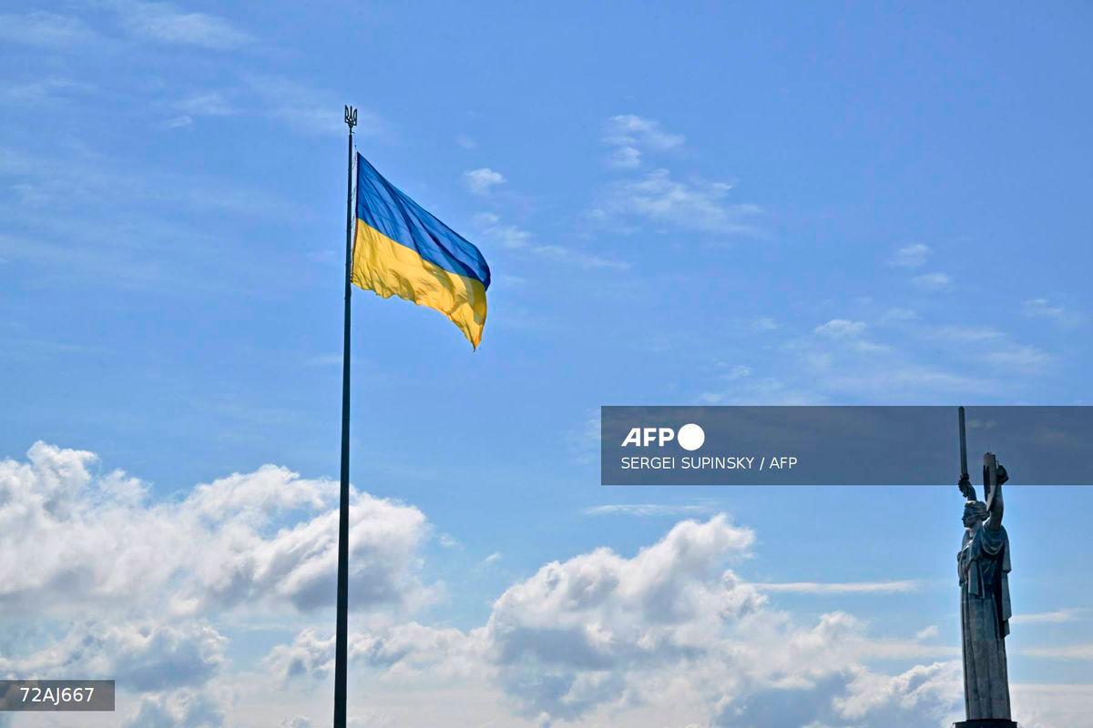 This photograph showsthe Ukrainian flag and the Motherland Monument (R) in Kyiv on August 23, 2025, a day before the Independence Day of Ukraine, amid Russian invasion in Ukraine. - AFP