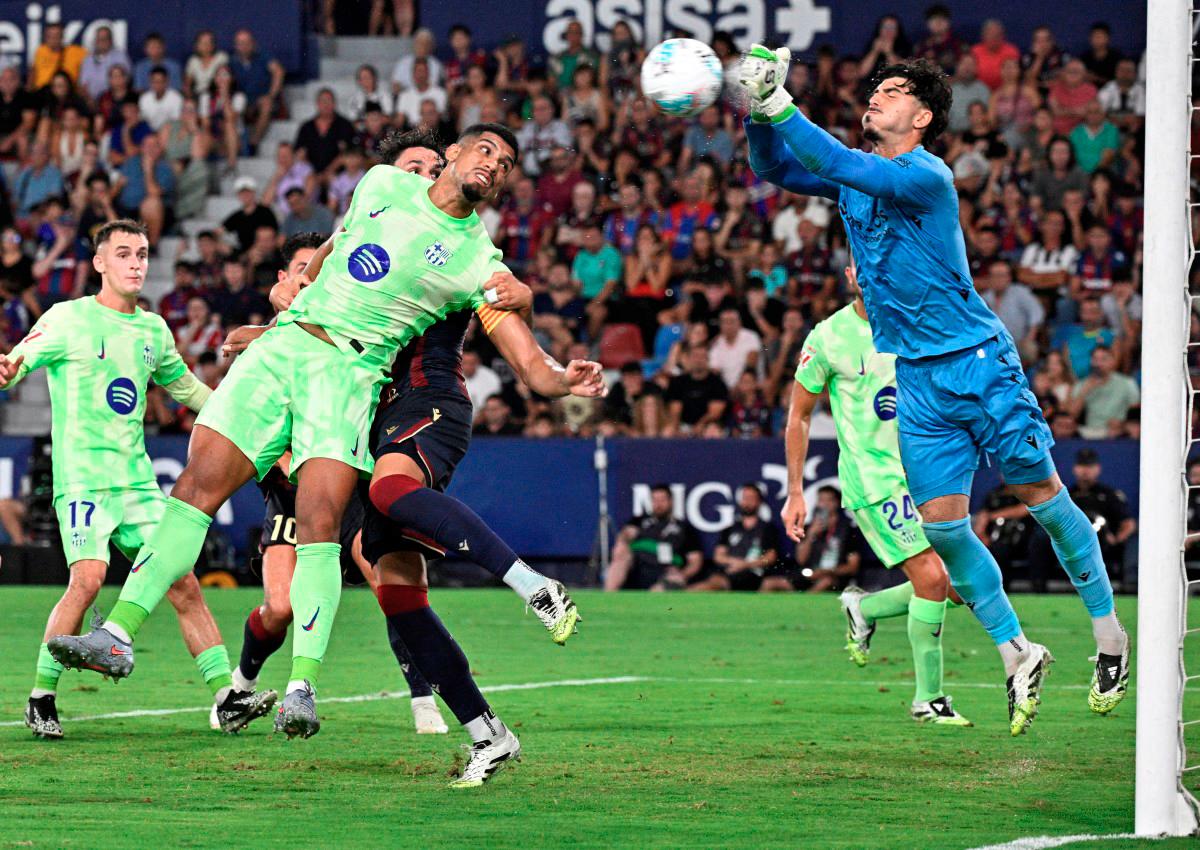 Barcelona’s Uruguayan defender Ronald Federico Araujo da Silva challenges Levante’s Spanish goalkeeper Pablo Campos during the Spanish league football match between Levante UD and FC Barcelona at Ciutat de Valencia Stadium in Valencia. - AFP