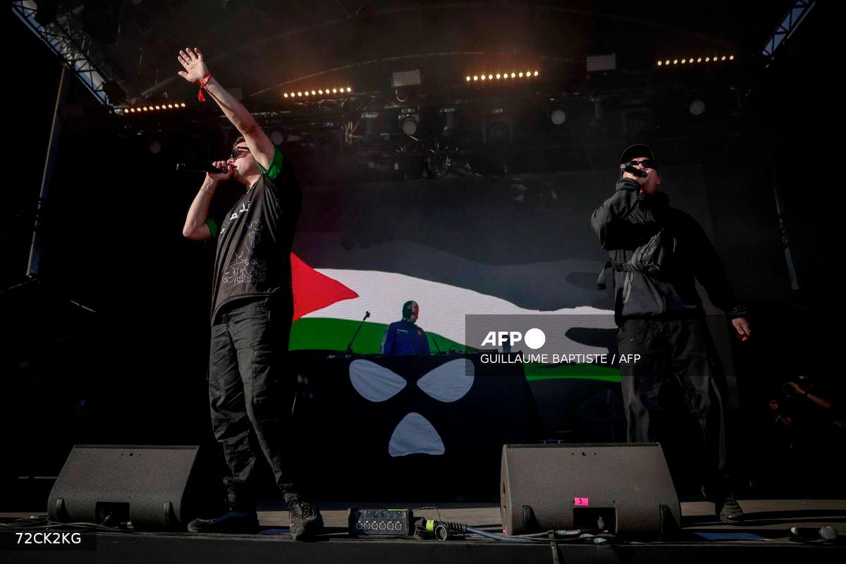 Northern Ireland hip-hop band Kneecap perform on stage in front of a Palestinian flag on a screen during a concert at the Rock en Seine music festival in Saint-Cloud, near Paris, on August 24, 2025. - AFP