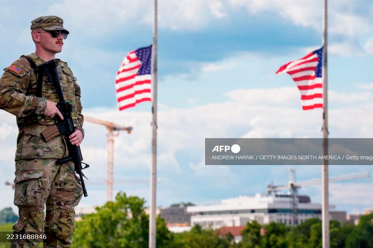 An armed member of the National Guard stands at the base of the Washington Monument on the National Mall on August 27, 2025 in Washington, DC. - Getty Images via AFP