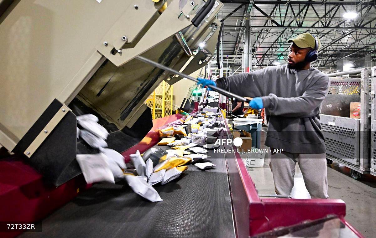 (FILES) Postal workers sort through mail and packages during a media tour hosted by the US Postal Service at the Los Angeles Processing and Distribution Center, the largest in the country, equivalent to 29 football fields, on Nov 30, 2023. Photo by Frederic J. BROWN / AFP