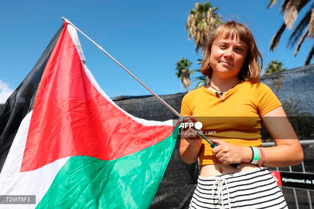 Swedish climate activist Greta Thunberg poses with a Palestinian flag as a flotilla carrying humanitarian aid and activists prepare to leave for Gaza, in Barcelona on August 30, 2025. (Photo by LLUIS GENE / AFP)