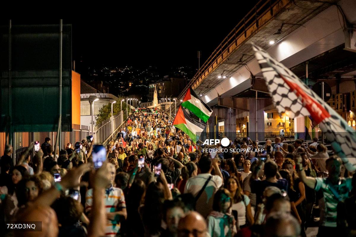 People march during a procession from the Music For Peace humanitarian organization headquarters to the nearby harbor where four boat are waiting to leave for Gaza joining the “Global Sumud Flotilla”, on August 30, 2025. (Photo by Federico SCOPPA / AFP)