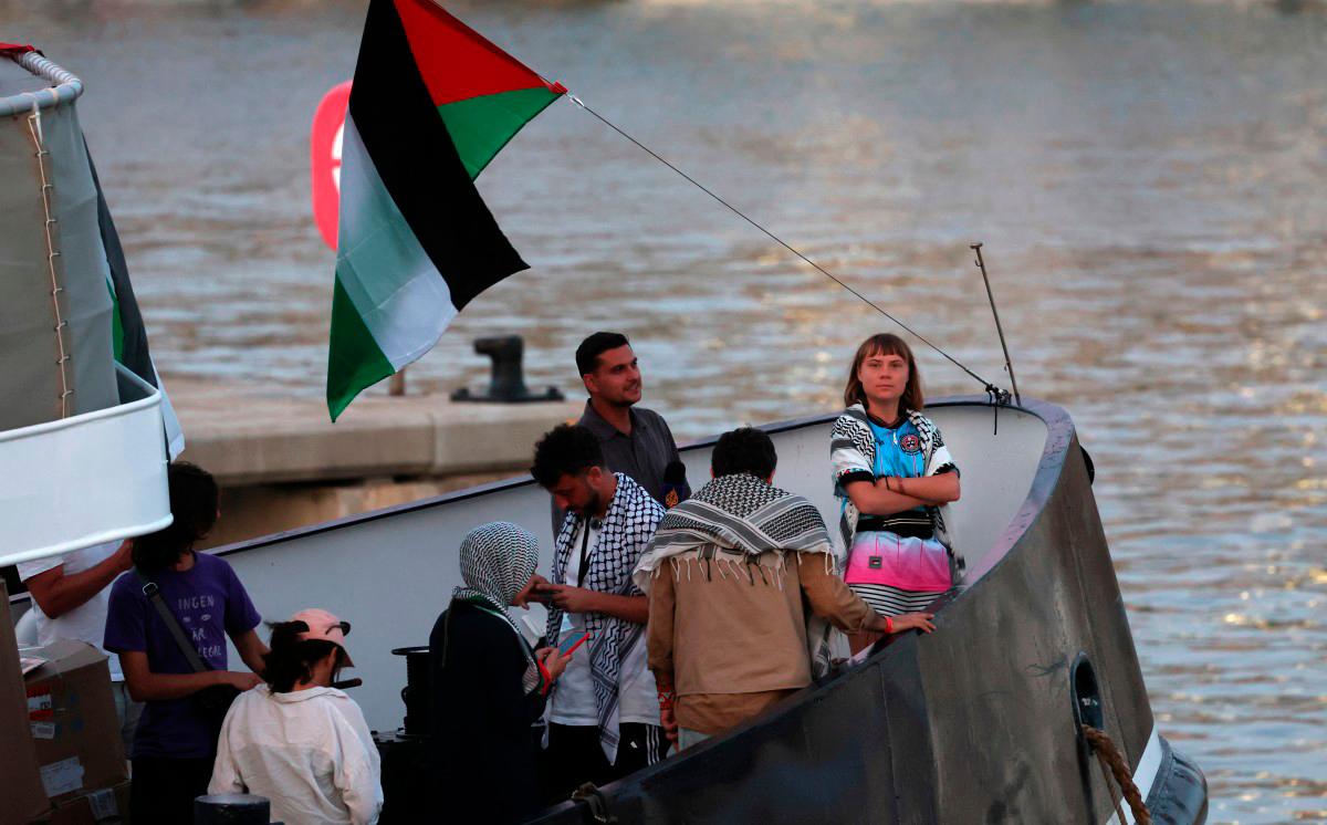 Swedish climate activist Greta Thunberg (R) is seen on board of a vessel of a civilian flotilla, carrying pro-Palestinian activists, and humanitarian aid and aiming to break the Israeli blockade of the Gaza Strip. - Lluis GENE / AFP