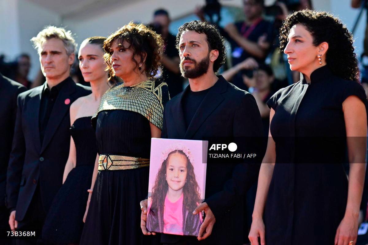 From left : US actor Joaquin Phoenix, US actress Rooney Mara, Tunisian director Kaouther Ben Hania, actor Motaz Malhees and actress Clara Khoury pose with a portrait of late Palestinian girl Hind Rajab during the red carpet for the movie The Voice of Hind Rajab presented in competition at the 82nd International Venice Film Festival, at Venice Lido on September 3, 2025. - AFP