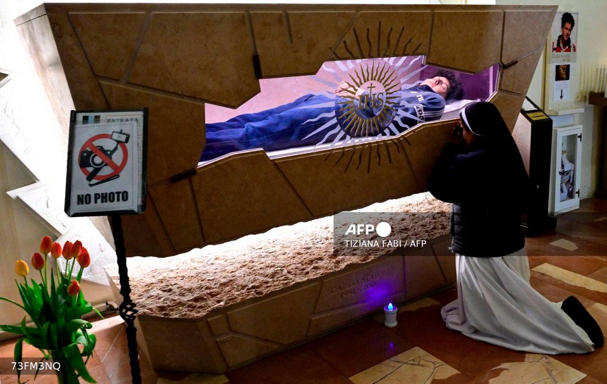 A nun prays at the tomb of Blessed Carlo Acutis, an adolescent who spent his life spreading his faith online, earning the moniker God's Influencer, in the Shrine of the Renunciation in Assisi, part of the Church of Saint Mary Major, on April 3, 2025. - AFP