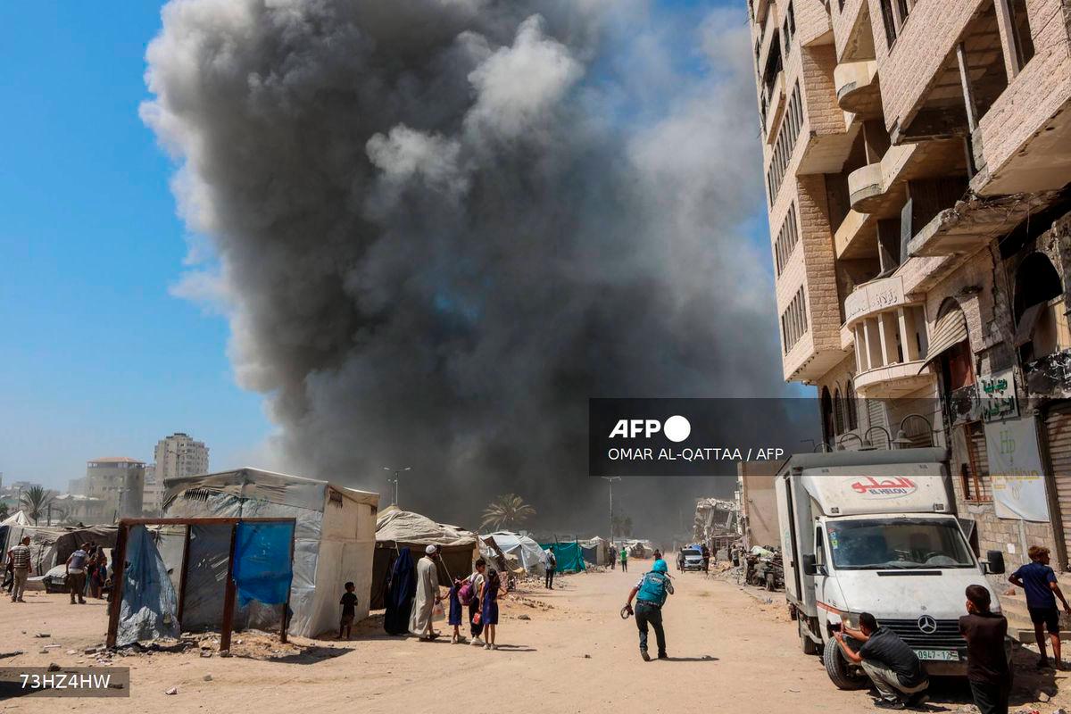 People watch as smoke billows during an Israeli strike on the Mushtaha Tower in Gaza City on September 5, 2025, amid the war between Israel and the Hamas militant movement. - AFP