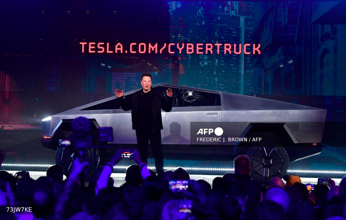 Tesla co-founder and CEO Elon Musk speaks in front of the newly unveiled all-electric battery-powered Tesla's Cybertruck with shattered windows, after a failed resistance test, at Tesla Design Center in Hawthorne, California, on November 21, 2019. - AFP
