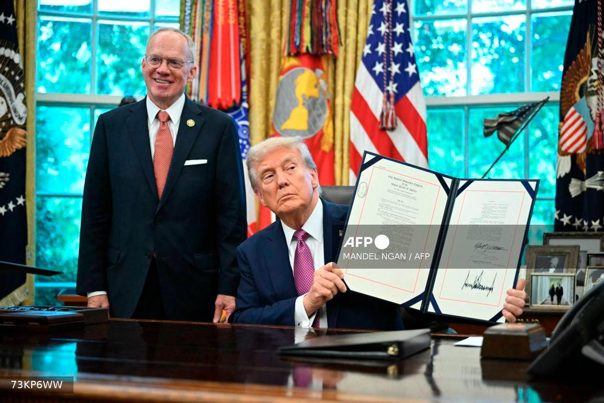 US President Donald Trump (R) shows a signed executive order next to US Representative John Rose, Republican of Tennessee, in the Oval Office of the White House in Washington, DC on September 5, 2025. - AFP