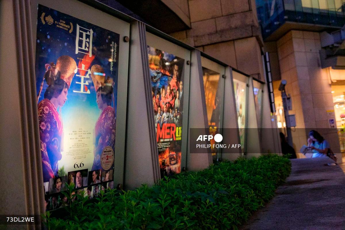 The poster of Japanese movie Kokuho (L) is pictured outside a cinema in Tokyo's Roppongi district on September 4, 2025. - AFP