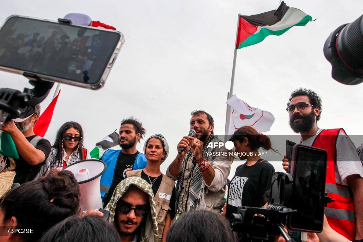 Brazilian activist Thiago Avila speaks to the crowd of pro-Palestinian activists that arrived to greet the Global Sumud Flottila at the port of the village of Sidi Bou Said on September 7, 2025. - Yassine Mahjoub / AFP