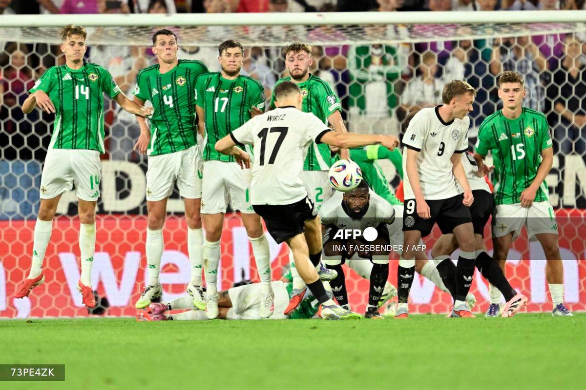 Germany's midfielder #17 Florian Wirtz (C) kicks to score the 3-1 goal during the 2026 World Cup qualifiers Europe zone group A football match between Germany and Northern Ireland on September 7, 2025 in Cologne, western Germany. - AFP