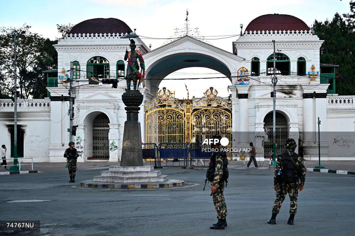 Army personnel stand guard near Singha Durbar, the main administrative building for the Nepal government, after it was set ablaze by protesters in Kathmandu on September 11, 2025. - AFP