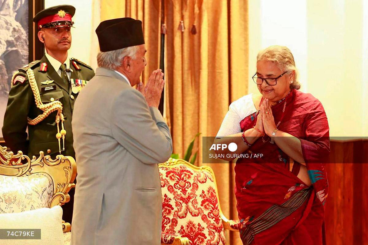 Nepal’s President Ram Chandra Paudel (L) gestures after administering the oath to the country’s newly appointed Prime Minister Sushila Karki during her swearing-in-ceremony at the President House in Kathmandu on September 12, 2025. Nepal’s former chief justice Sushila Karki was sworn on September 12 to lead the transition as the country’s next prime minister after deadly anti-corruption protests ousted the government. (Photo by Sujan GURUNG / AFP)