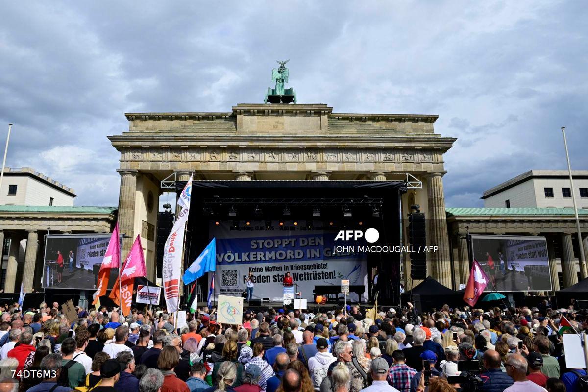 A general view shows Sahra Wagenknecht, co-founder and co-leader of the left-wing populist party Sahra Wagenknecht Alliance (BSW), as she speaks on a stage during a rally titled “Stop the genocide in Gaza! No weapons in war zones! Peace instead of arms race!” on September 13, 2025 at the Brandenburg Gate in Berlin. (Photo by John MACDOUGALL / AFP)